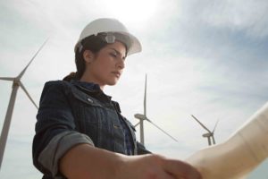 engineer at wind farm holding plans