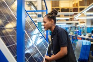 Quality engineer examining solar panels in factory