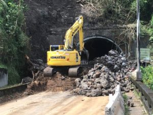 Construction equipment digging rock rubble from tunnel