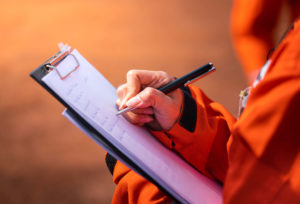 engineer takes notes on clipboard.