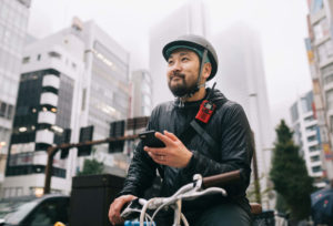 Bike messenger holding cell phone