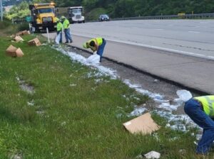 Workers picking up litter alongside the road