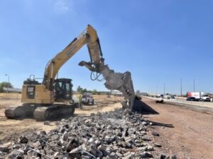 Heavy machinery scooping rocks out of a ditch.