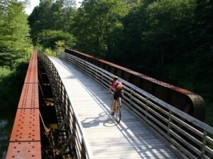 A person riding their bike over a bridge.