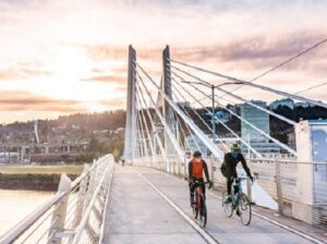 People riding bikes across a bridge.